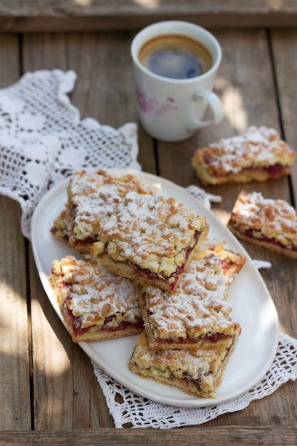 Torta streusel recheada com geleia de rosas, servida com café. estilo rústico.