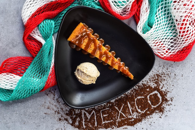 Torta Tlatelolco o Torta de maíz con helado de café en plato negro con bandera mexicana