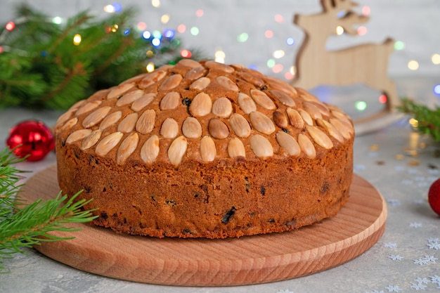 Torta tradicional de Navidad Dundee con frutos secos y almendras en una tabla de madera Postre festivo