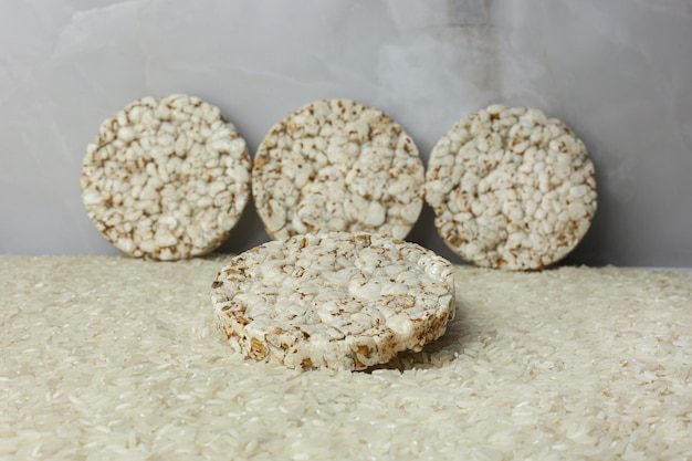 Torta de trigo sarraceno de arroz de pie sobre un fondo de grañones de arroz esparcidos