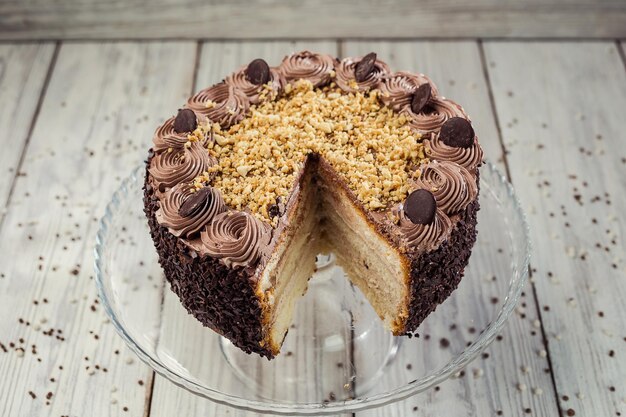 Foto torta vegana de chocolate oscuro con dulces y nueces sobre fondo de madera