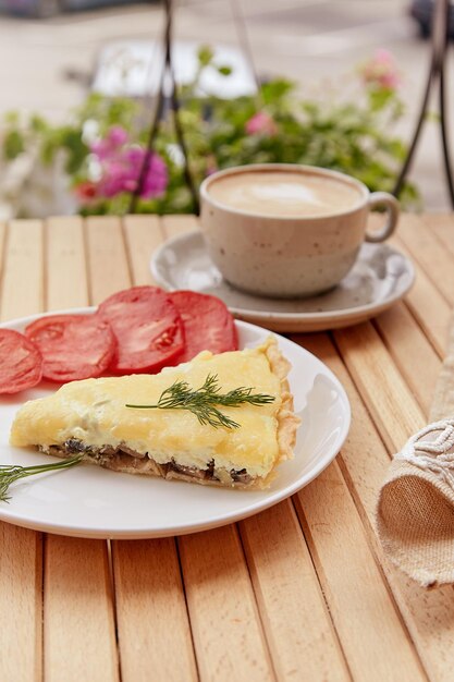 Torta vegetariana natural tradicional com cogumelos e queijo adyghe, tomate e endro Xícara de café Almoço saudável Comida francesa