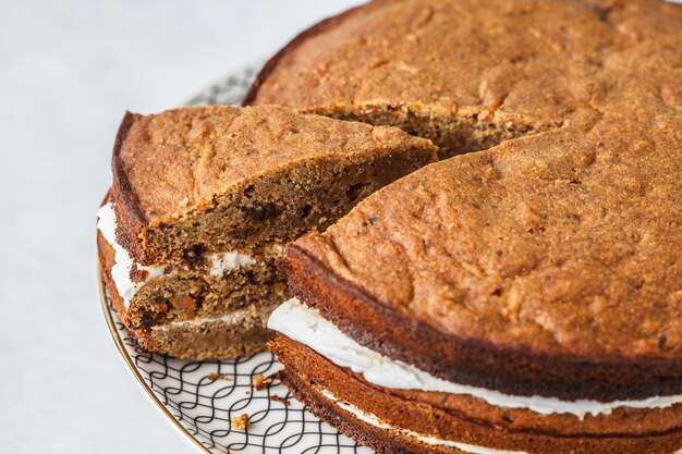 Torta de zanahoria del vegano con la crema del coco, fondo blanco.