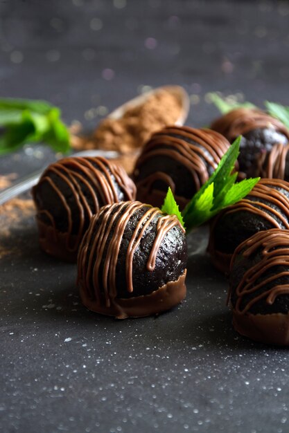 Tortas de bolas de chocolate con hojas de menta sobre fondo oscuro.