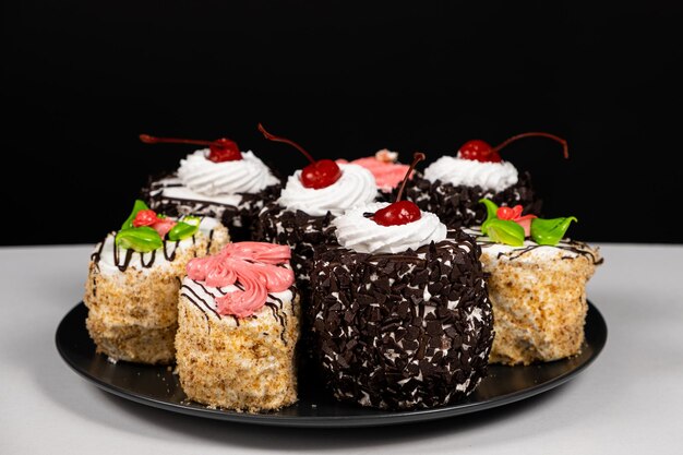 Tortas con cerezas de chocolate y crema sobre un fondo negro