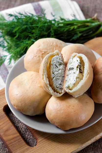 Tortas com queijo cottage salgado e verdes em uma placa de madeira