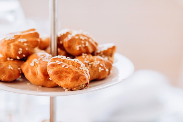 Tortas com sementes de gergelim em um prato de várias camadas. mesa de buffet na festa.