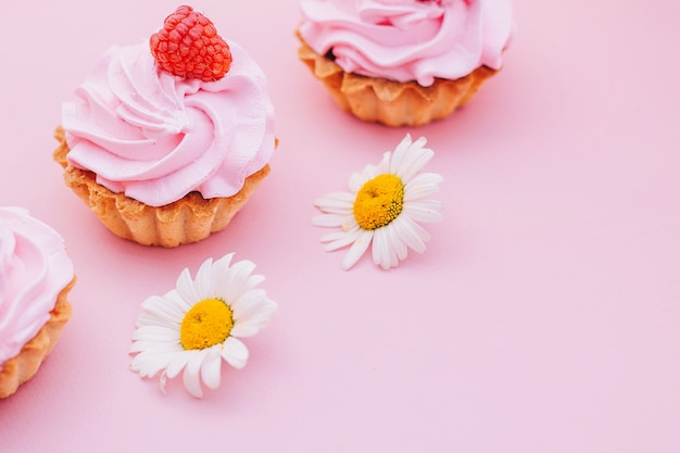 tortas con crema de aire con frambuesas sobre un fondo rosa