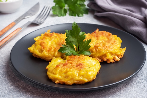 Tortas fritas de patatas ralladas con salsa.