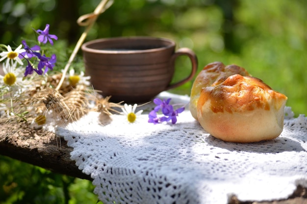 Tortas y leche del desayuno del país en el banco en el jardín