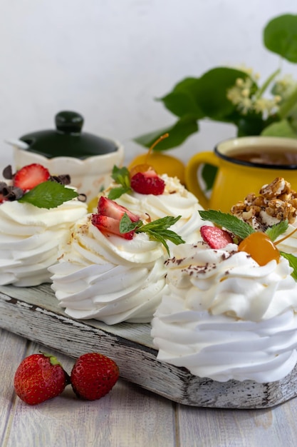 Tortas de merengue de Pavlova con crema batida y hojas de menta de fresas frescas Enfoque selectivo
