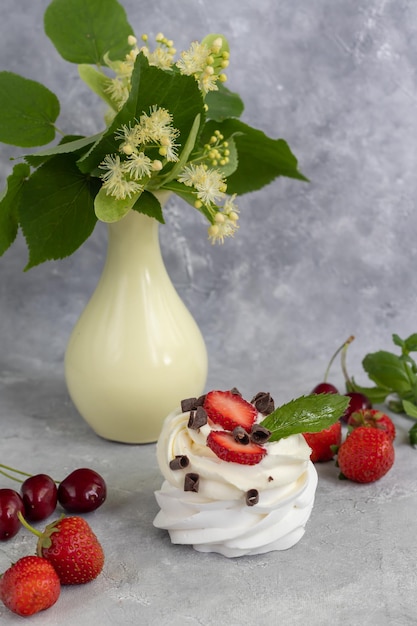 Tortas de merengue de Pavlova con crema batida y hojas de menta de fresas frescas Enfoque selectivo