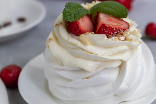 Tortas de merengue de Pavlova con crema batida y hojas de menta de fresas frescas Enfoque selectivo