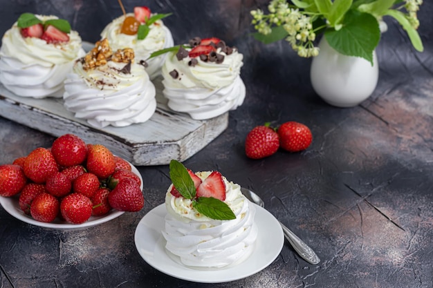 Tortas de merengue de Pavlova con crema batida y hojas de menta de fresas frescas Enfoque selectivo