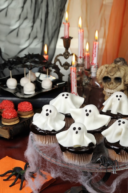 Tortas de smorgasbord en glaseado de chocolate decoradas con fantasmas de mazapán en Halloween