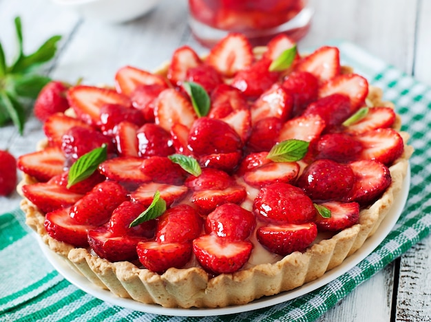 Torte mit Erdbeeren und Schlagsahne, geschmückt mit Minzblättern