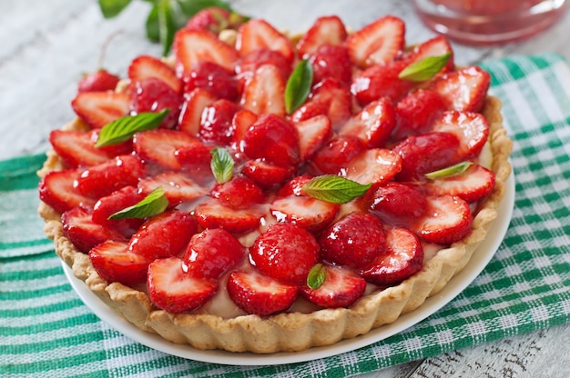 Torte mit Erdbeeren und Schlagsahne, geschmückt mit Minzblättern