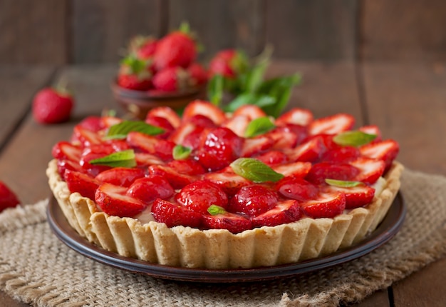 Torte mit Erdbeeren und Schlagsahne, geschmückt mit Minzblättern