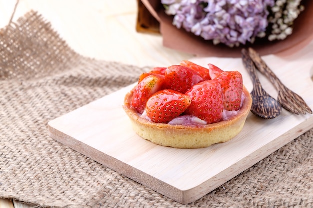 Foto torte mit frischer erdbeere auf hölzernen hintergrund,