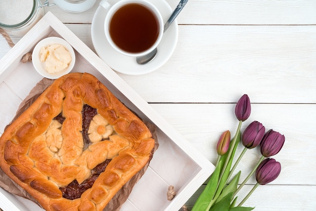 Torte mit Fruchtfüllung und Tulpen auf hellem Hintergrund. Draufsicht mit Platz zum Kopieren.