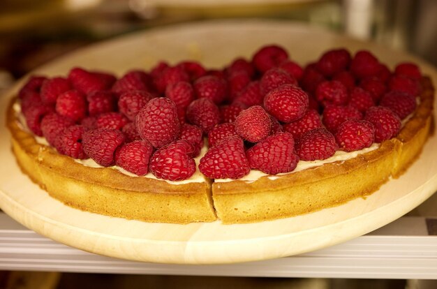 Torte mit Himbeeren und Schlagsahne, dekoriert mit Minzblättern