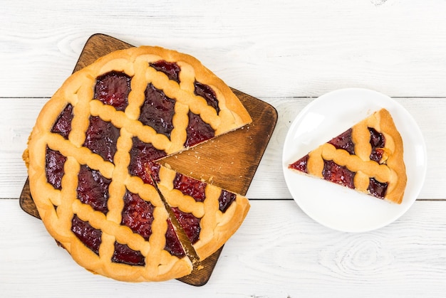 Torte mit Kirschmarmelade auf Draufsicht des hölzernen Hintergrundes