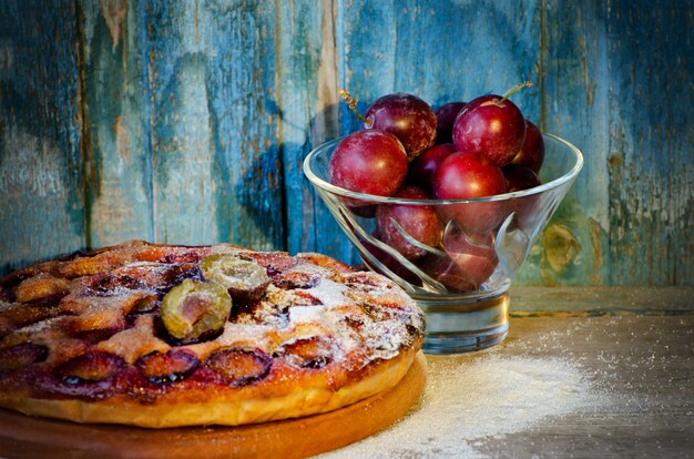 Torte mit Pflaumen und frischen Pflaumen in eine Schüssel geben