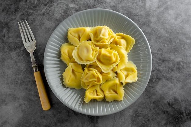 Tortellini cocinado en un plato, pasta de cerca, comida italiana.