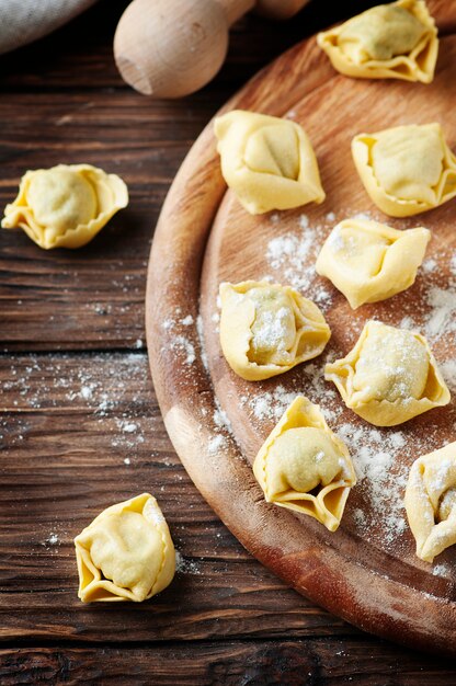 Tortellini tradicional italiano casero en la mesa de madera