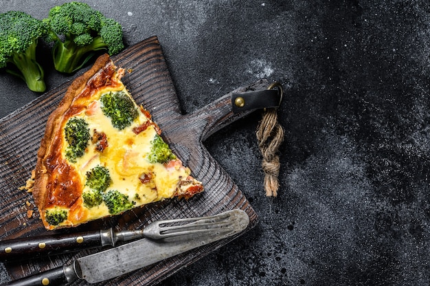 Tortenquiche mit rotem Fischlachs und Brokkoli. Schwarzer Hintergrund. Draufsicht. Speicherplatz kopieren.