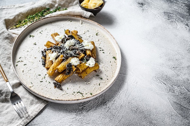 Tortiglioni de pasta con trufa negra y Boletus edulis, seta blanca. Fondo gris Vista superior. Espacio para texto