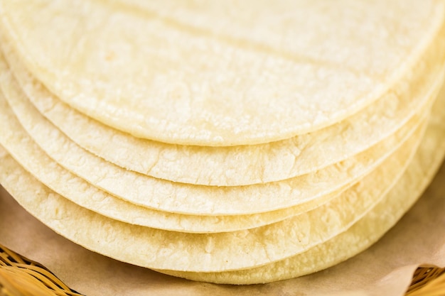 Tortilhas de milho branco fresco em um fundo de madeira.