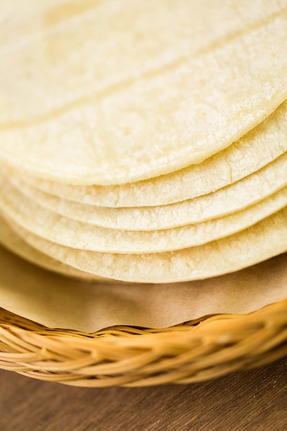 Tortilhas de milho branco fresco em um fundo de madeira.