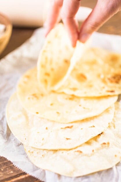 Tortilhas de milho branco fresco em um papel branco.