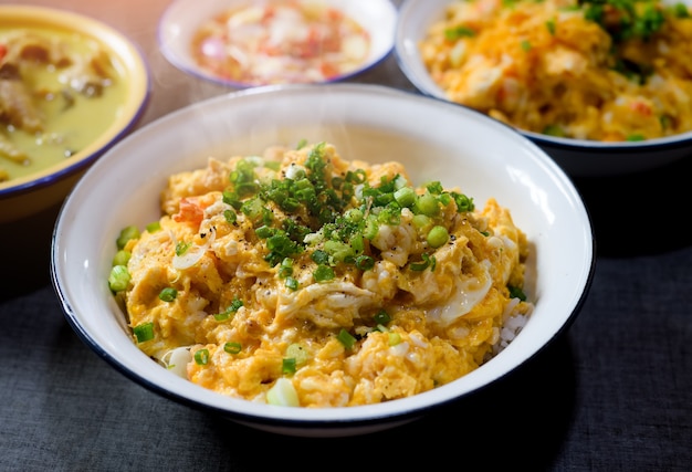 Tortilla de camarones picados estilo asiático con arroz y cebolla con luz de sol matutino.
