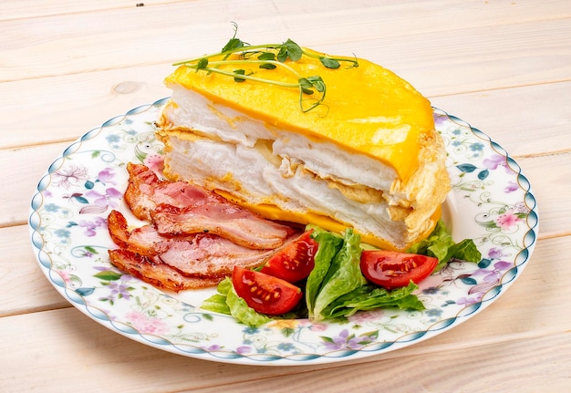 Tortilla en capas con tocino frito y verduras frescas Desayuno