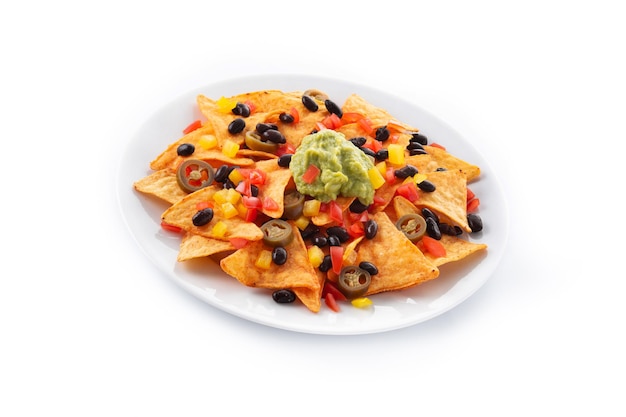 Tortilla chips de nachos mexicanos con frijoles negros, guacamole, tomate y jalapeño aislado sobre fondo blanco.