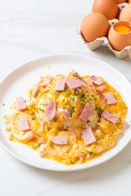 Foto tortilla cremosa con jamón sobre arroz o arroz con jamón y tortilla suave