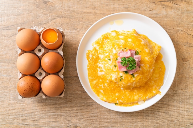 Foto tortilla cremosa con jamón sobre arroz o arroz con jamón y tortilla suave