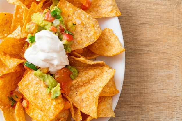 Tortilla de nachos mexicanos com jalapeño, guacamole, molho de tomate e molho