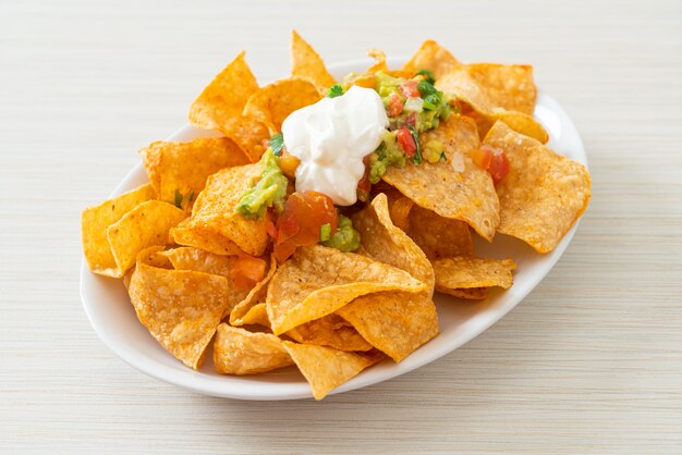 Tortilla de nachos mexicanos com jalapeño, guacamole, molho de tomate e molho