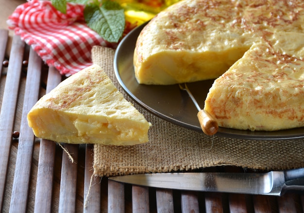 Tortilla española con patata y huevo, acompañada de aceite de oliva.