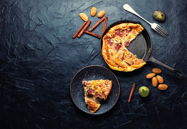 Tortilla con higos y almendras en una sartén. Copiar el espacio