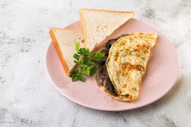 Tortilla con hongos y pan tostado aislado sobre fondo de mármol blanco. Comida hecha en casa. Desayuno sabroso Enfoque selectivo. Foto hotizontal.