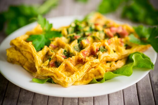 Tortilla de huevo rellena de verduras y salchicha frita en forma de gofres