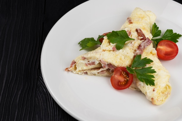 Tortilla de jamón y queso sobre fondo de madera negra