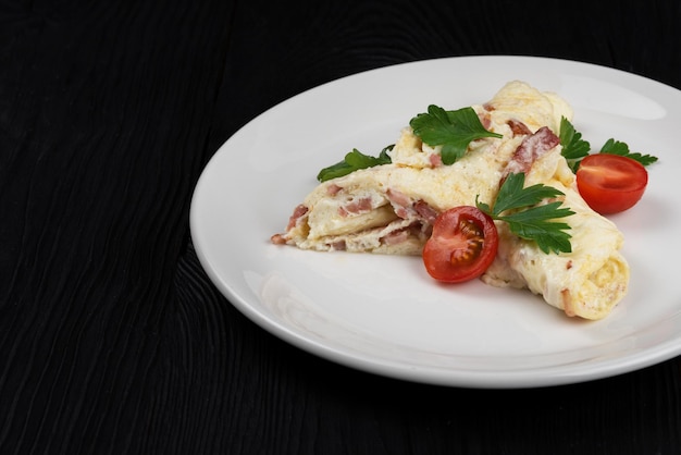 Tortilla con jamón y queso y verduras frescas sobre fondo de madera negra