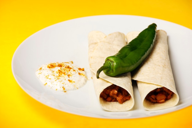 Foto tortilla mexicana con carne de res sobre fondo amarillo