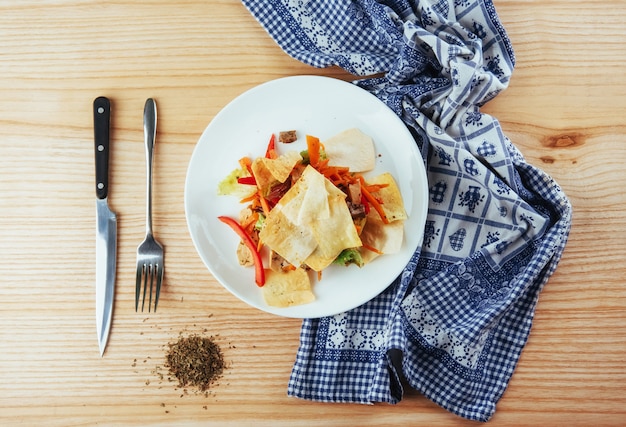 Tortilla mexicana com salada em uma mesa de madeira.