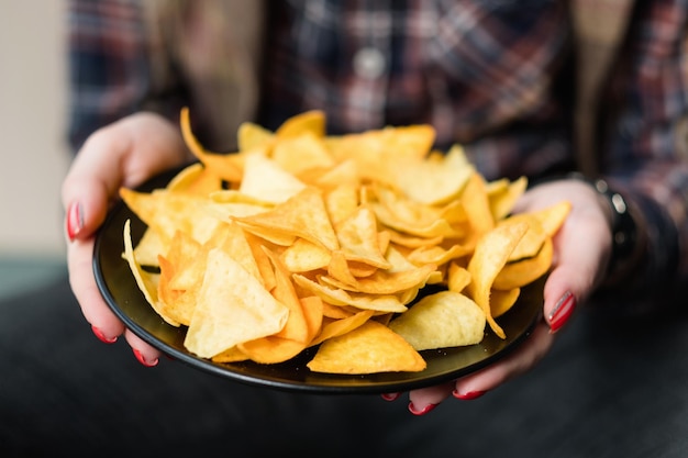 Tortilla nacho chips receita de comida mão de mulher oferecendo um prato de batatas fritas naturais